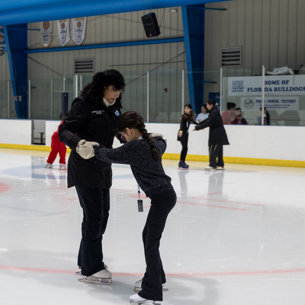 Skating Coach assisting a child during an ice skating class at the ice factory.