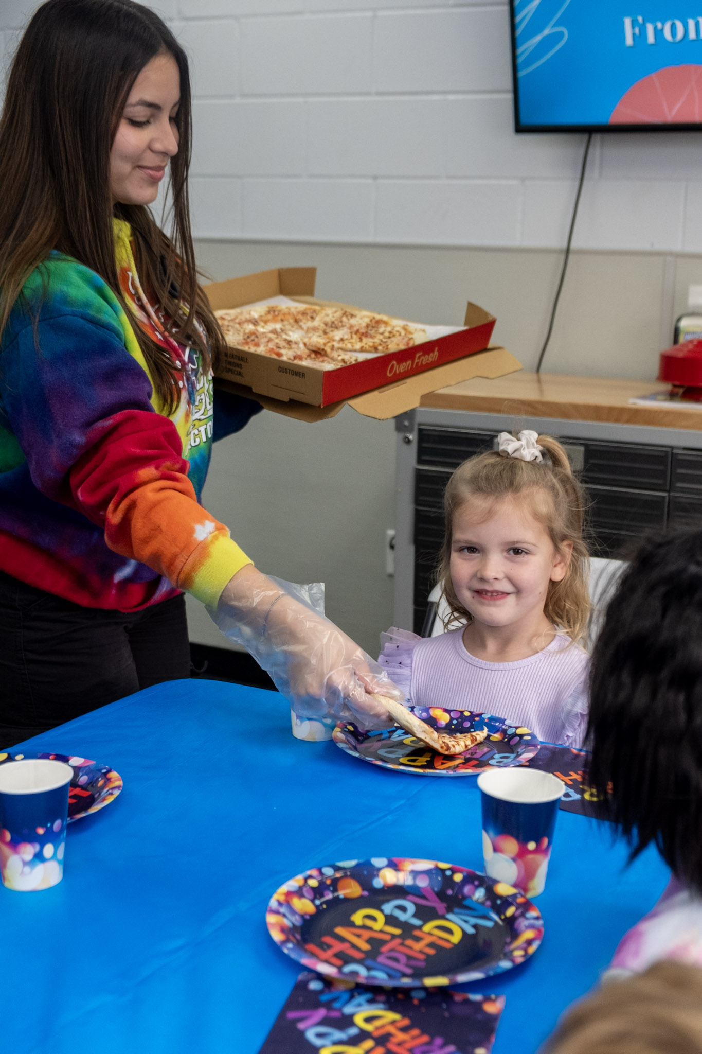 A birthday party girl excited to get a fresh slice of home made pizza at the Ice Factory