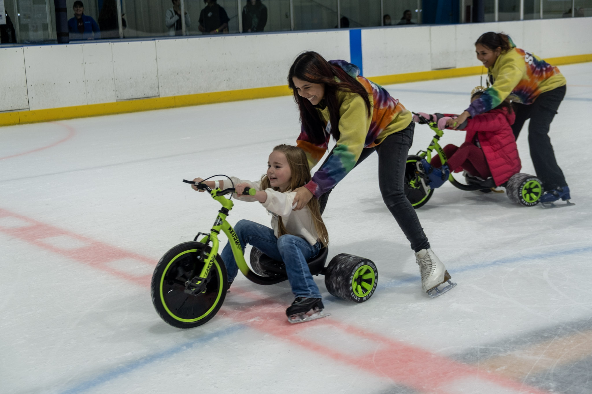 A Birthday party child guest of honor riding on a tricycle race as a unique birthday party activity at the Ice Factory